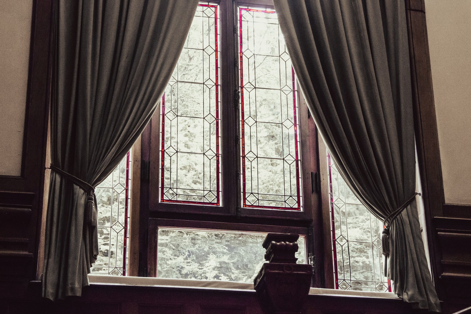 a window with curtains and a clock in front of it